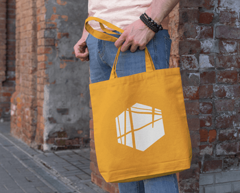 mockup-of-a-man-holding-a-tote-bag-next-to-a-brick-wall-192-el.png