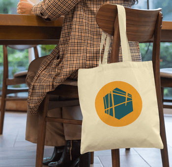 tote-bag-mockup-of-a-woman-sitting-on-a-chair-29457.png